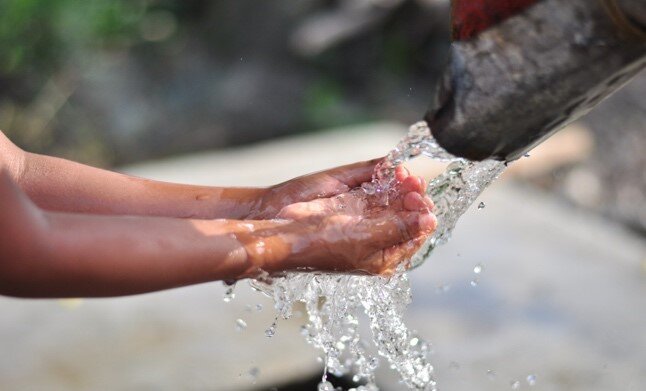 Clean water pouring into cupped hands