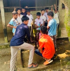 Schoolchildren collecting water from the existing hand pump before the water tank project in rural Netrokona.