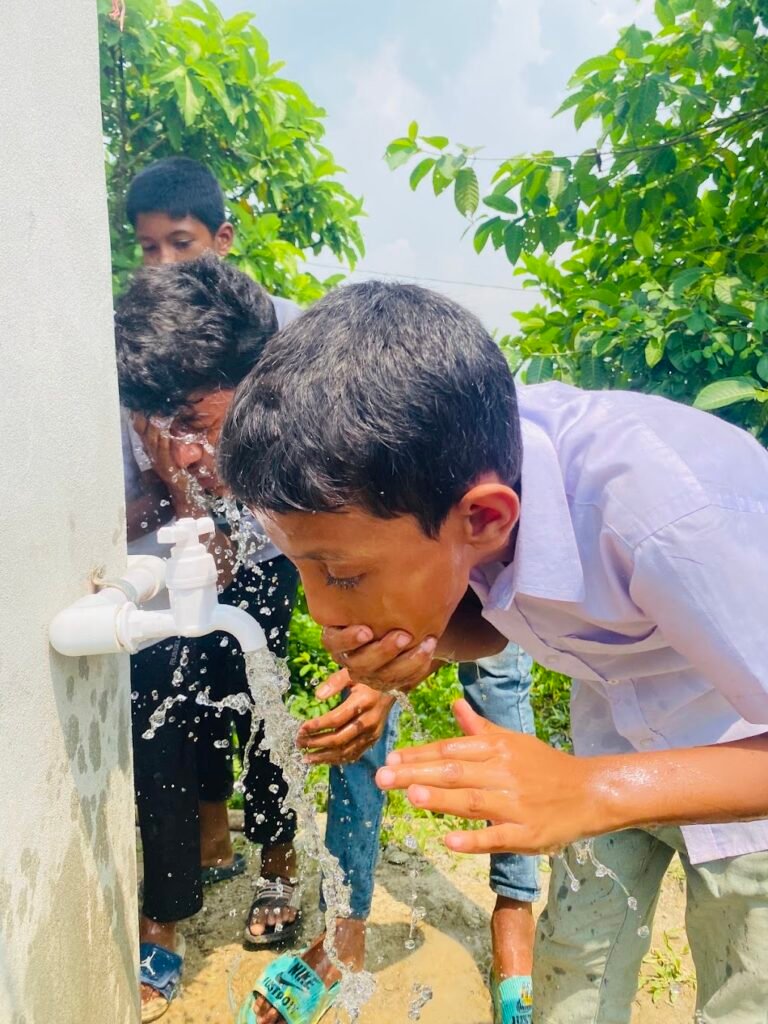 Students drinking clean water from a newly installed water facility at their school in Bangladesh