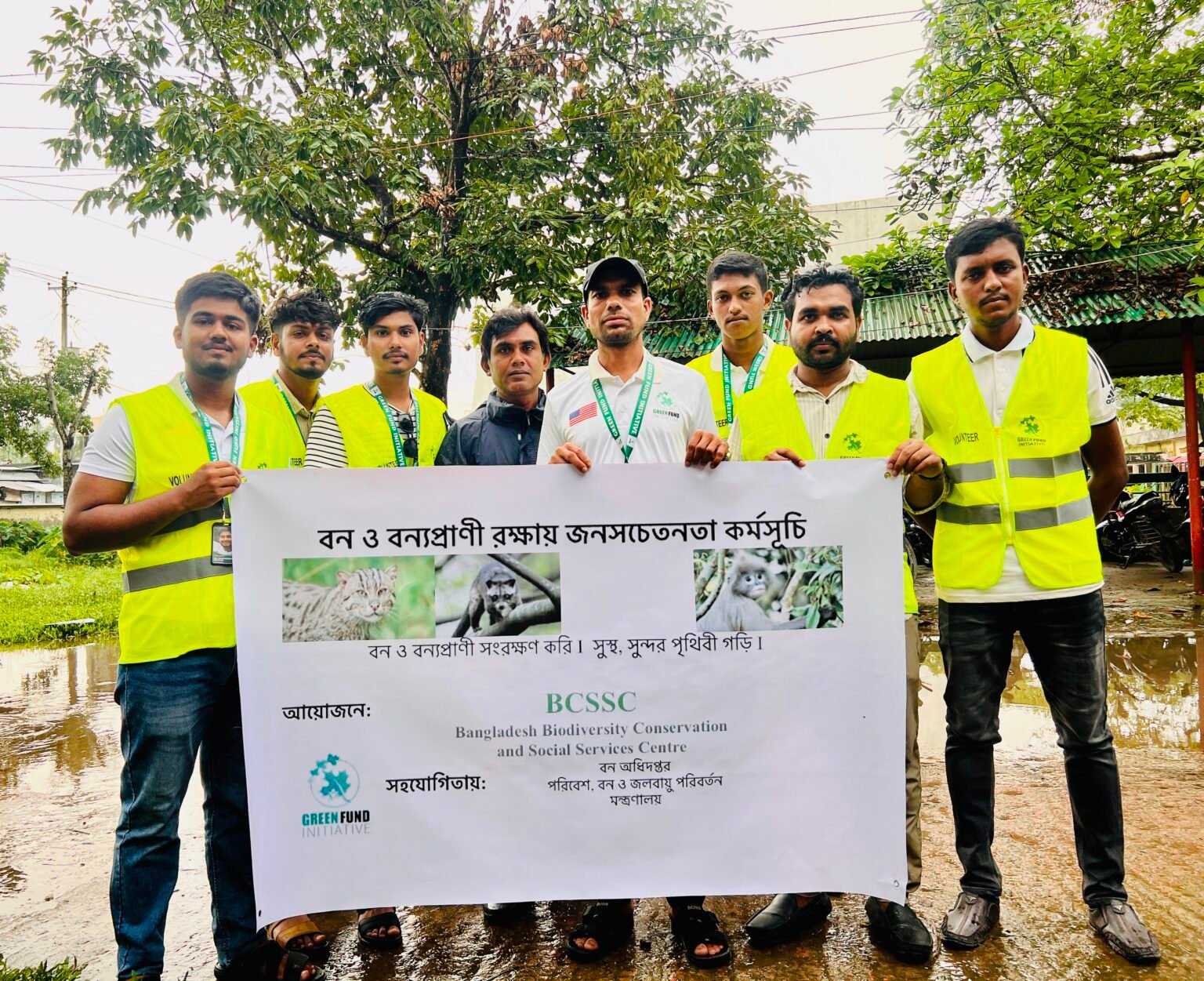 Green Fund Initiative volunteers in safety vests holding a wildlife conservation campaign banner