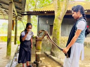 Schoolchildren collecting water from the existing hand pump before the water tank project in rural Netrokona.